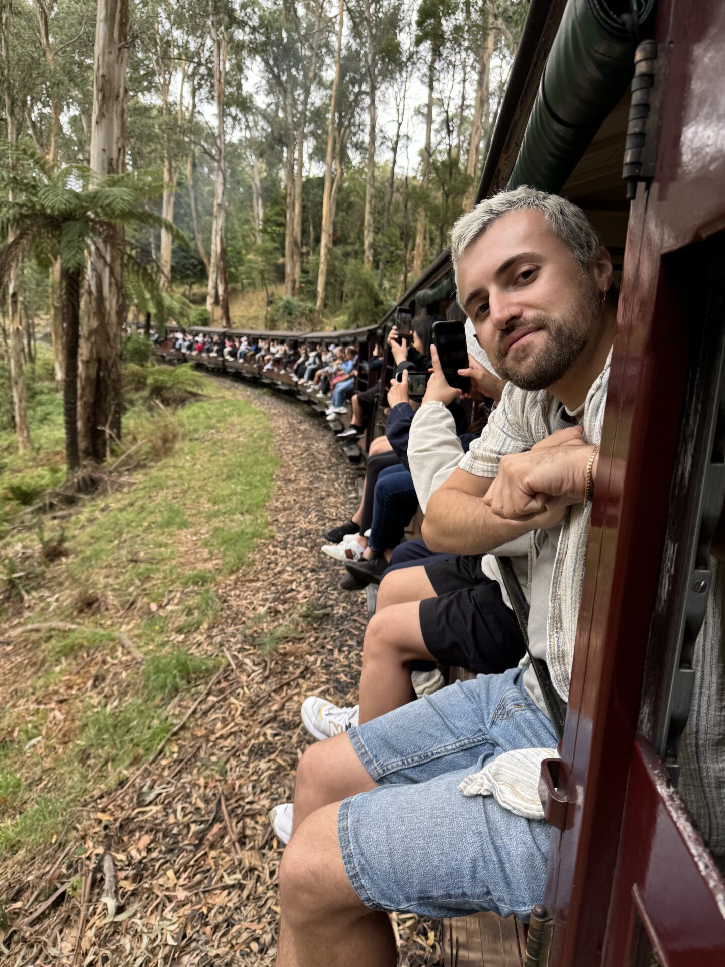 Young man sitting with legs over the side of the open side carriages.